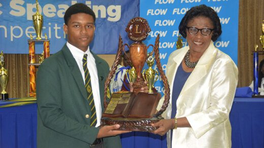 2023 Public Speaking Champion, Christian Joseph, left, receives the Lion Michael DeFreitas challenge trophy from Governor General of St Vincent and the Grenadines, Dame Susan Dougan.