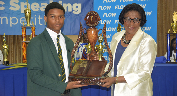 2023 Public Speaking Champion, Christian Joseph, left, receives the Lion Michael DeFreitas challenge trophy from Governor General of St Vincent and the Grenadines, Dame Susan Dougan.