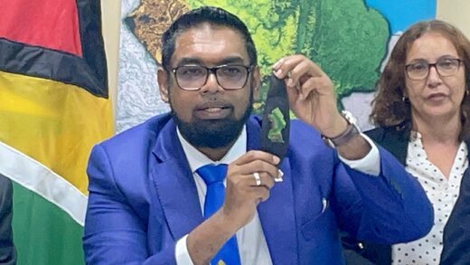 President Irfaan Ali showing off his wristband with the map of Guyana as he updates the media on the ongoing border talks with Venezuelan leader Nicolas Maduro at Argyle International Airport on Thursday, Dec. 14, 2023. (CMC Photo)