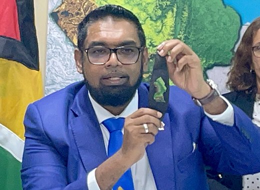 President Irfaan Ali showing off his wristband with the map of Guyana as he updates the media on the ongoing border talks with Venezuelan leader Nicolas Maduro at Argyle International Airport on Thursday, Dec. 14, 2023. (CMC Photo)