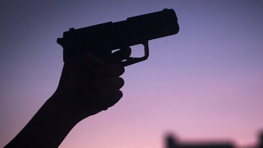 Hand of young woman holding pistol revolver gun