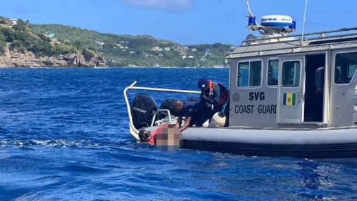 A fisherman hands over one of the bodies to Coast Guard personnel after retrieving it from the aeroplane, which sank to the seabed after crashing off Petit Nevis on Thursday, Jan. 4, 2024.
