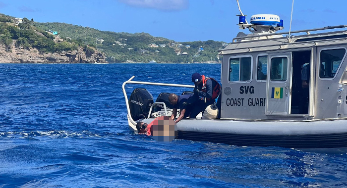 A fisherman hands over one of the bodies to Coast Guard personnel after retrieving it from the aeroplane, which sank to the seabed after crashing off Petit Nevis on Thursday, Jan. 4, 2024.