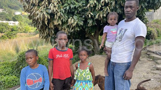 Jason "Candle" Samuel and his children after the fire destroyed their house in Upper Questelles on Saturday, Feb. 3, 2024.