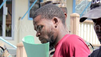 Grenadian escaped prisoner Ron Mitchell in police custody outside the Kingstown Magistrate's Court on Monday, Feb. 26, 2024.