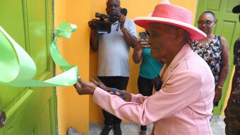 Clementina Lavia, 97, said to be the oldest person in Sandy Bay, cuts the ribbon to officially open the Caribbean Ties Exhibition and Documentation Centre at Sandy Bay on March 17, 2024.