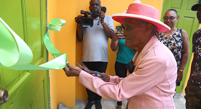 Clementina Lavia, 97, said to be the oldest person in Sandy Bay, cuts the ribbon to officially open the Caribbean Ties Exhibition and Documentation Centre at Sandy Bay on March 17, 2024.