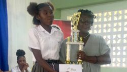 Macy Baptiste of Sandy Bay Secondary School receives the winner's trophy. 