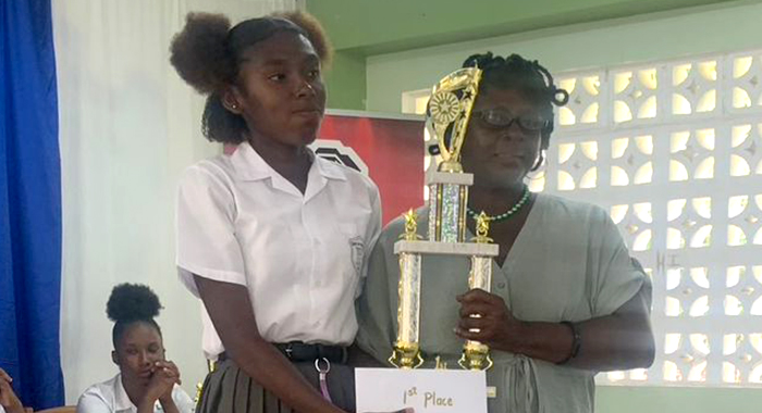 Macy Baptiste of Sandy Bay Secondary School receives the winner's trophy. 