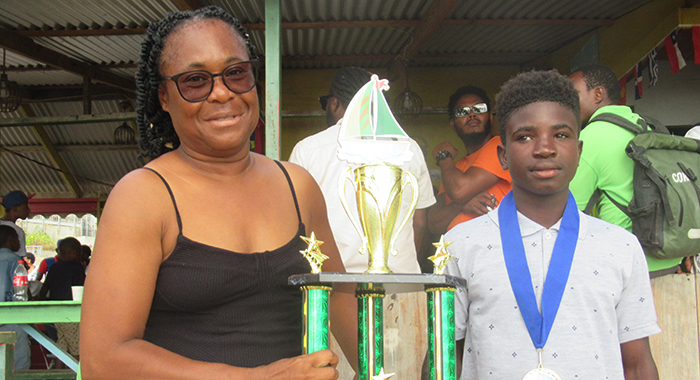 Mayreau Junior Sailors' president Helen Forde presenting the Most Outstanding Sailor trophy to 14-year old Jerimiah Forde,