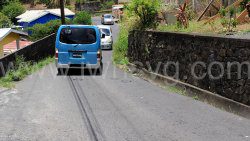 A minivan reverses to give way to another vehicle along the narrow stretch of road in Lower Questelles on Sunday, May 12, 2024.