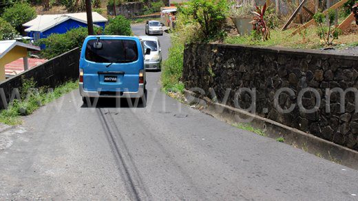 A minivan reverses to give way to another vehicle along the narrow stretch of road in Lower Questelles on Sunday, May 12, 2024.