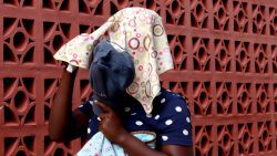Shontel Jackson hides her face on Thursday, May 23, 2024 as she leaves the Colonarie Magistrates Court sitting at Georgetown. 