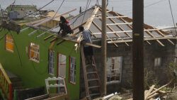 People work on Tuesday, July 9, 2024, to repair a storm-damaged house in Mayreau. Hurricane Beryl damaged some 3,500 homes in St. Vincent and the Grenadines on July 1, 2024, according to government estimates.