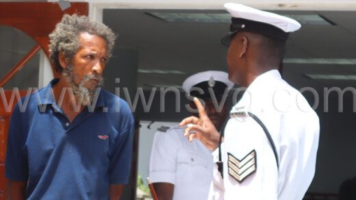 The defendant Randy Harry, left, speaks with a police officer outside the Colonarie Magistrate on Thursday, July 25, 2024.