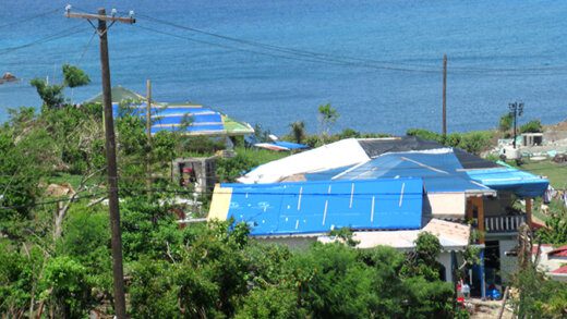 Tarpaulins on some homes in Mayreau that fared well but had roof damage leading to water damage inside.