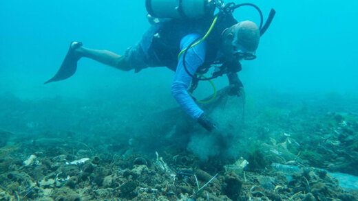 Serenity dive Scuba team member picking up ocean debris. (Photo by Stephan Hornsey, SVGEF Fund Manager)