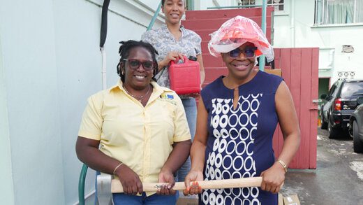 From left: VEEP Project Officers Davina Roberts and Niska Stewart handing over clean-up equipment to Permanent Secretary in the Ministry Of Agriculture, Nerissa Gittens.