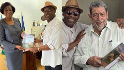 Richard Byron Cox presents copies of his book to Governor General of St. Vincent and the Grenadines Dame Susan Dougan, left, and Prime Minister Ralph Gonsalves.