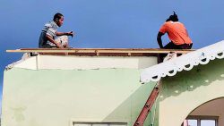 Men repair a house roof in September. (Photo: Facebook/API)