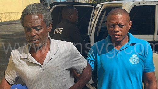 Police officers escort murder accused Eros Cain, 63, left, to the Serious Offences Court on Monday, Jan. 6, 2025.