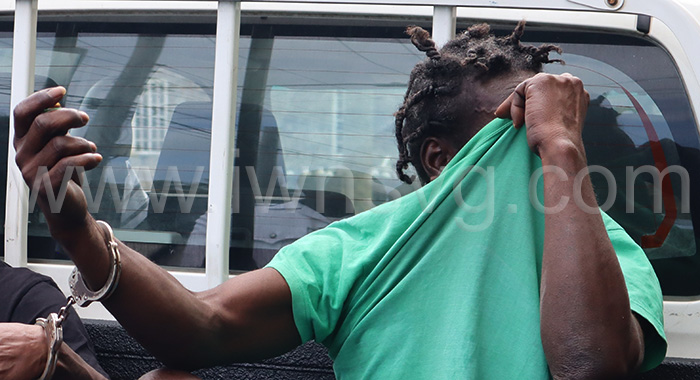 The defendant, Collin Phil Blake aka Shitcop hides his face in Georgetown as he awaits transportation to prison on Monday, Feb. 24, 2025.