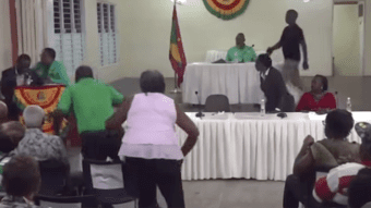 NNP supporters rush to aid former Grenada prime minister, Keith Mithcell as he stumbles shortly after saying he was “blacking out” while speaking at a public meeting in Grenada on Monday, March 17, 2025.