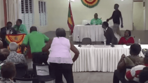 NNP supporters rush to aid former Grenada prime minister, Keith Mithcell as he stumbles shortly after saying he was “blacking out” while speaking at a public meeting in Grenada on Monday, March 17, 2025.