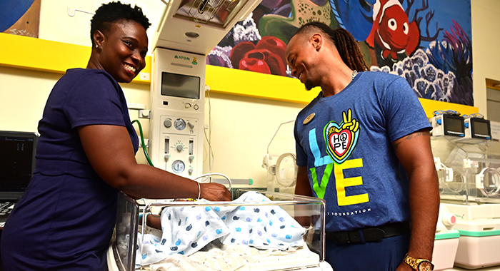 Dr. Akousa Horne-Cupid, a paediatrician at the Milton Cato Memorial Hospital, left, demonstrates the correct usage of the new infant warmer to Ike Abbott, a Sandals Foundation Ambassador and team member at Sandals Saint Vincent & the Grenadines.