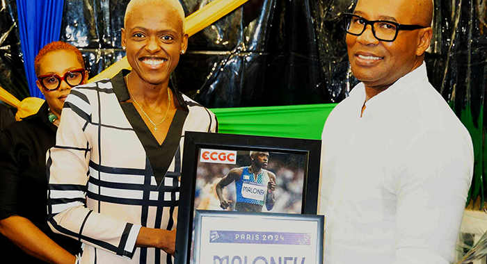 Shafiqua Maloney, left, presents J. Robert Cato, CEO of ECGC with an Olympic bib and autographed photo at the “The Inspiration” Fundraiser on March 8, 2025. 