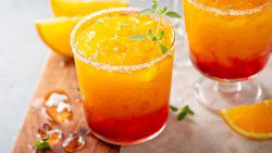 Tequila sunrise margarita cocktail in different glasses with ice, refreshing summer drink