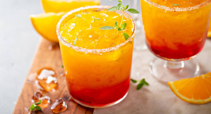 Tequila sunrise margarita cocktail in different glasses with ice, refreshing summer drink