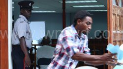 The defendant, Tyson Young tries to avoid being photographed outside the Georgetown Magistrate's Court on March 24, 2025.