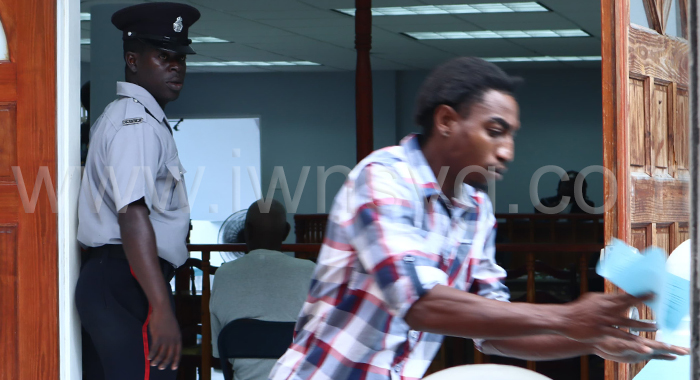 The defendant, Tyson Young tries to avoid being photographed outside the Georgetown Magistrate's Court on March 24, 2025.