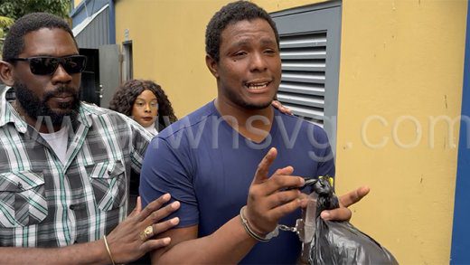 Murder Kesroy Ryan, right, is escorted from the Serious Offences Court in Kingstown by detective Station Sergeant Biorn Duncan on May 26, 2025.