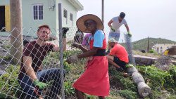 Some of the international students work along with residents of Mayreau to erect a fence around a home garden in that southern Grenadines island.