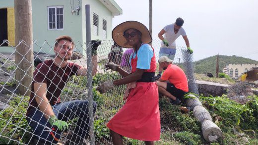 Some of the international students work along with residents of Mayreau to erect a fence around a home garden in that southern Grenadines island.