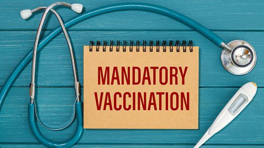 Notepad with text Mandatory Vaccination, thermometer and stethoscope. Medical concept.