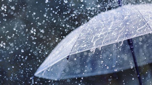 Transparent umbrella under heavy rain against water drops splash background. Rainy weather concept.