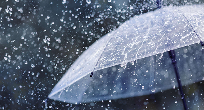 Transparent umbrella under heavy rain against water drops splash background. Rainy weather concept.