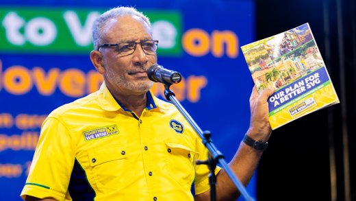 Opposition Leader Godwin Friday holds up a copy of his New Democratic Party 2025 election manifesto in Keartons, Barrouallie on Thursday, Nov. 19, 2025. (Photo: Facebook/NDP)