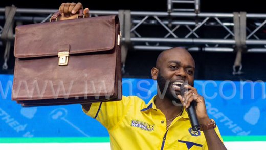 New Democratic Party candidate for North Leeward, Kishore Shallow, holds up a brief bag, which he said contains files on members of the ruling Unity Labour Party, at the NDP's rally in Biabou on Nov. 1, 2025. (Photo: NDP)