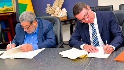 Prime Minister Ralph Gonsalves, left, and UK investor Zachary Bayman sign a US$100 million agreement for the redevelopment of Palm Island Resorts and Apa and the Anchorage Yacht Club in Kingstown on Monday, Nov. 17, 2025. (Photo: Facebook/APISVG)