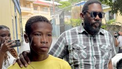 Detective Inspector Biorn Duncan, right, escorts the accused, Romano Warren, 18, outside the Serious Offences Court in Kingstown, on Monday, Nov. 24, 2025. 