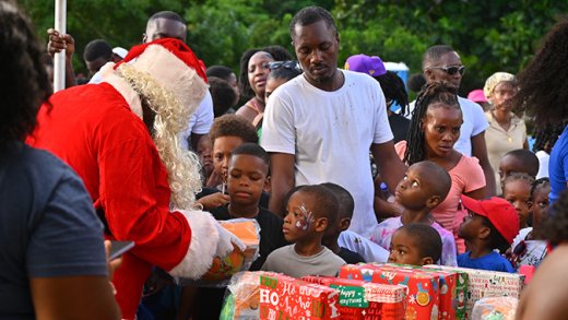 Children from the Buccament Bay Community receive gifts from the Sandals Foundation's Santa Claus.