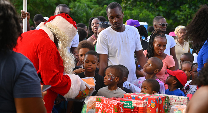 Children from the Buccament Bay Community receive gifts from the Sandals Foundation's Santa Claus.