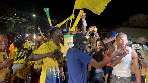 A group of young men celebrates the New Democratic Party’s election victory outside the party’s headquarters in Kingstown on Nov. 27, 2025. 