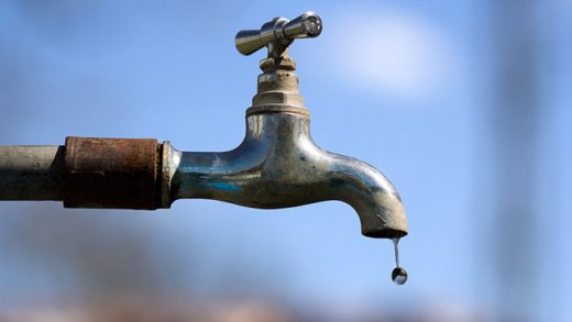 Water drop falling from an old tap