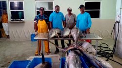Eli Slater, right, along with Fisheries Minister Conroy Huggin, second left, at the Kingstown Fish Market where Slater landed his winning catch on Monday, May 25, 2026. 