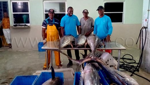 Eli Slater, right, along with Fisheries Minister Conroy Huggin, second left, at the Kingstown Fish Market where Slater landed his winning catch on Monday, May 25, 2026. 